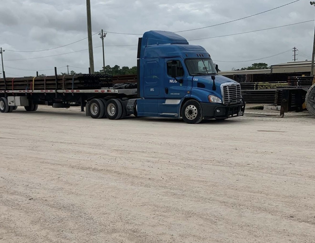 National Logistics Group tractor with a loaded flatbed trailer